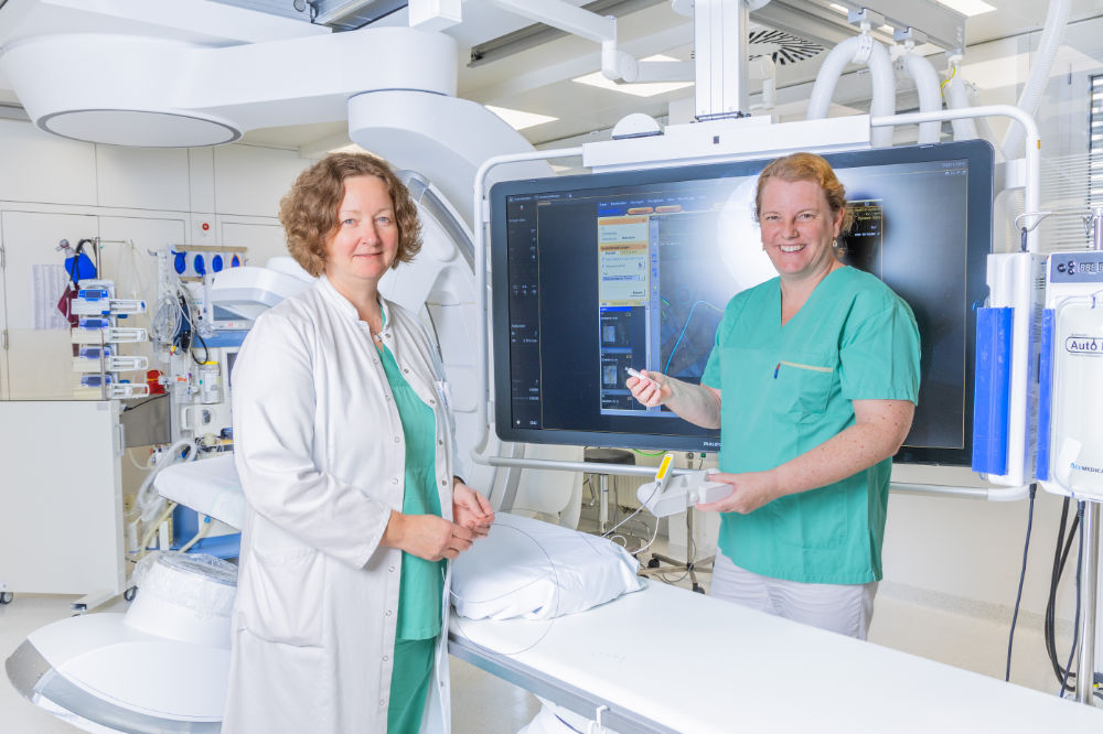 Radiologie-Direktorin Elke Gizewski (l) und Gefäßchirurgie-Direktorin Sabine Wipper halten den Lichtleiter-Draht Lumi Guide in den Händen. (Foto: MUI/C. Simon)