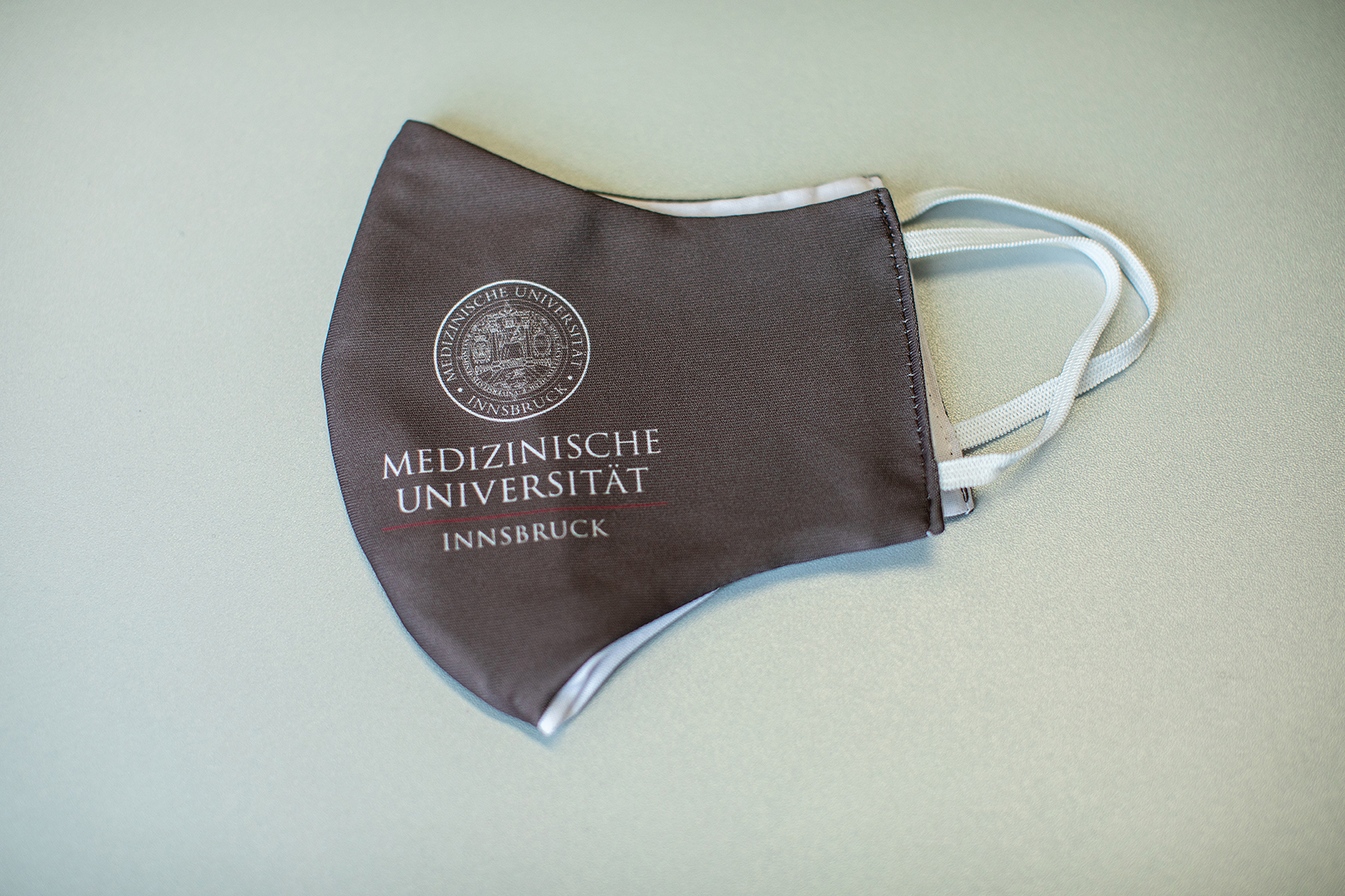 Mund-Nasen-Schutz mit Logo der Medizinischen Universität Innsbruck Farbe taupe
